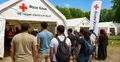 Migranci przed namiotami Czerwonego Krzyża - grafika poglądowa
