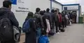 Migranci w kolejce do centrum azylowego - grafika poglądowa