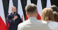 Karol Nawrocki przemawia. W tle polskie flagi, z przodu ludzie