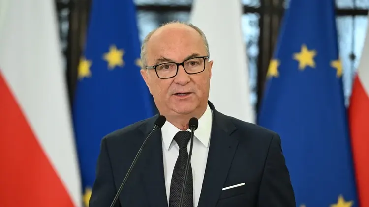 Włodzimierz Czarzasty przemawia do mikrofonu. W tle flaga Polski i UE