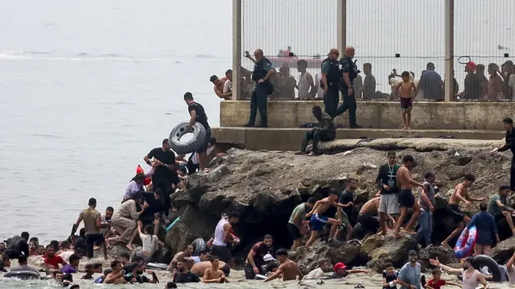 Migranci szturmujący wybrzeże Ceuty
