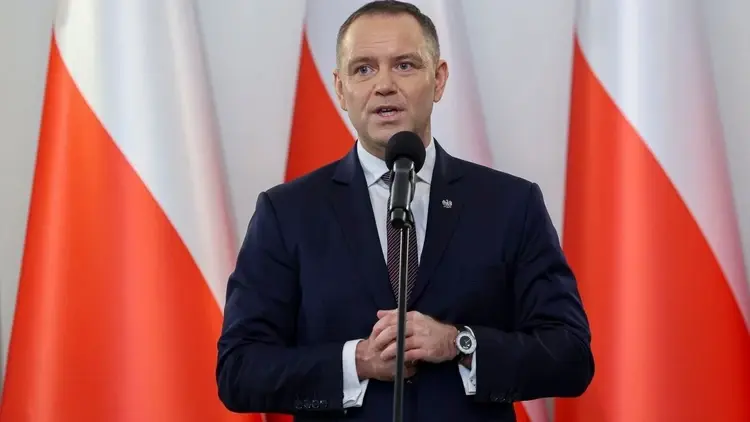 Karol NAwrocki przemawia na tle polskiej flagi