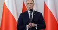 Karol NAwrocki przemawia na tle polskiej flagi