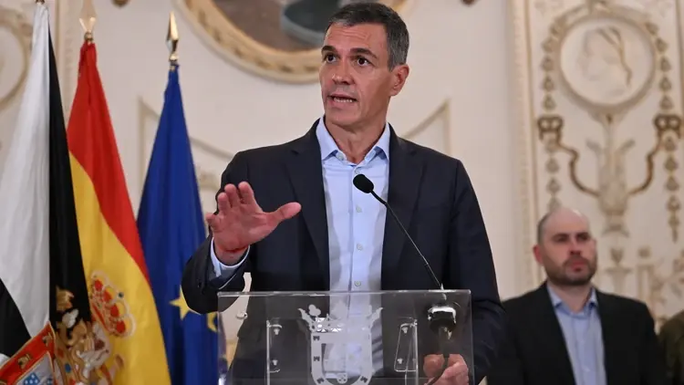Pedro Sanchez przemawia na konferencji prasowej. W tle flaga Hiszpanii i UE