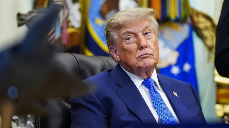 Donald Trump w garniturze, siedzi na skórzanym fotelu