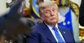 Donald Trump w garniturze, siedzi na skórzanym fotelu