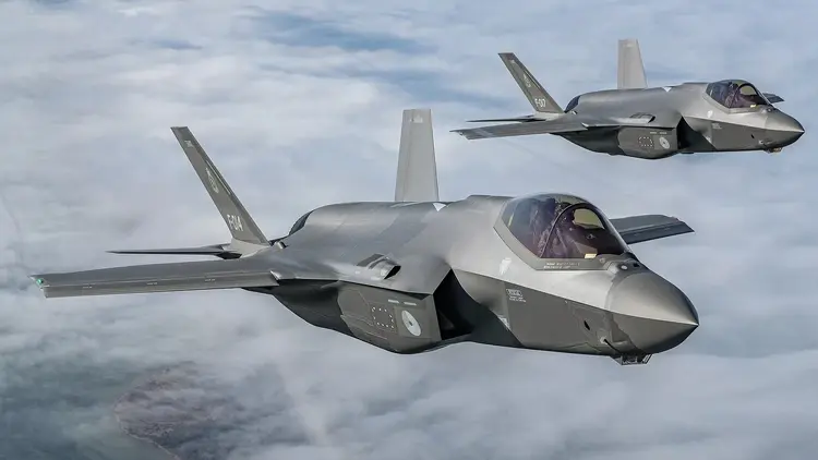 Dwa myśliwce F-35 w locie, w tle chmury i niebo