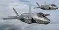 Dwa myśliwce F-35 w locie, w tle chmury i niebo