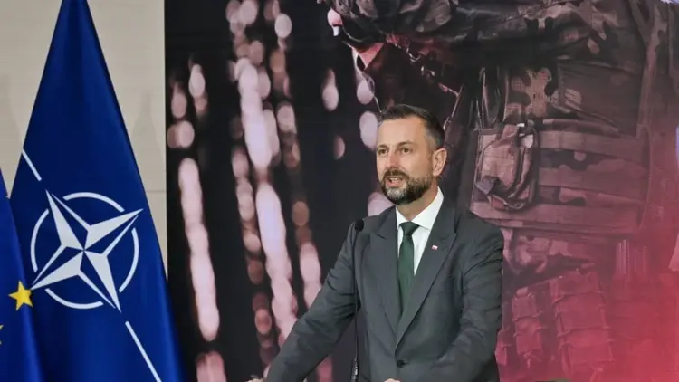 Władysław Kosiniak-Kamysz przemawia, w tle flaga NATO i zdjęcie żołnierza
