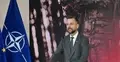 Władysław Kosiniak-Kamysz przemawia, w tle flaga NATO i zdjęcie żołnierza