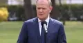 Donald Tusk przemawia do mikrofonu. W tle park