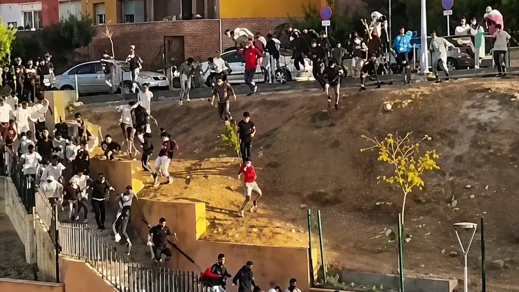 Migranci biegną przez Ceutę