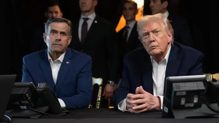 John Ratcliffe i Donald Trump siedzą przy stole. W tle ludzie