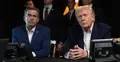 John Ratcliffe i Donald Trump siedzą przy stole. W tle ludzie