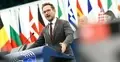 Waldemar Buda przemawia w PE, w tle flagi krajów UE