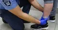 system nadzoru elektornicznego służba wiezienna montuje czujnik na nodze więźnia