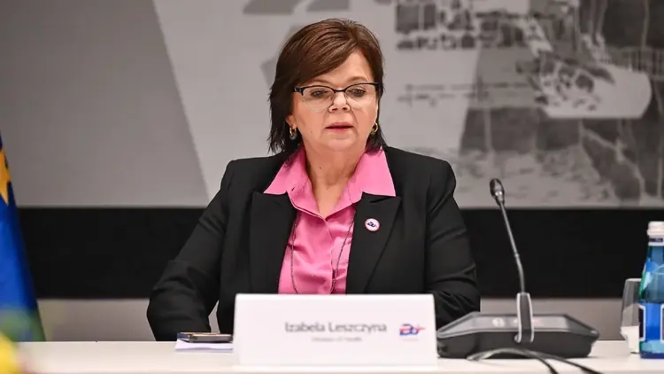 Izabela Leszczyna na konferencji, obok stoi mikrofon i woda