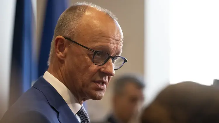 Friedrich Merz z profilu, w tle mężczyzna