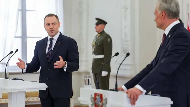 Prezydent Polski Karol Nawrocki przemawia do mikrofonu. W tle prezydent Litwy