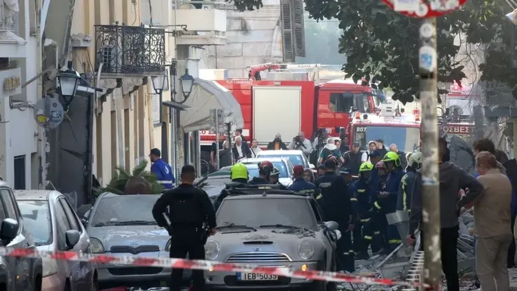 Firefighters work at the scene of a partially collapsed two-story building on Lysikratous Street in the Plaka district of Athens