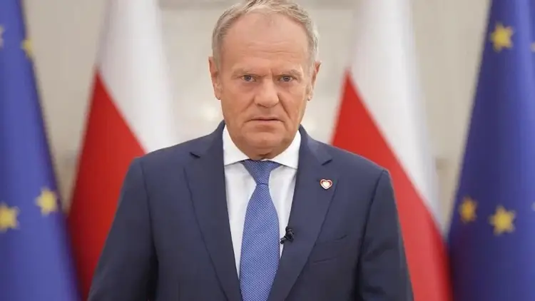 Donald Tusk, w tle flagi Polski i UE