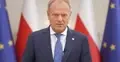 Donald Tusk, w tle flagi Polski i UE