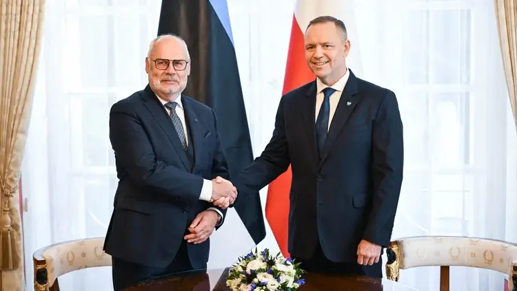 Alar Karis i Karol Nawrocki ściskają sobie dłonie, w tle flagi Polski i Estonii