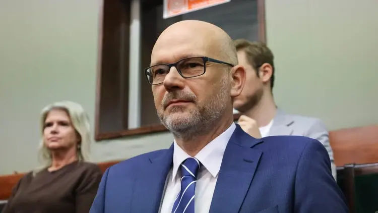 Maciej Berek w Sejmie. W tle dwie osoby