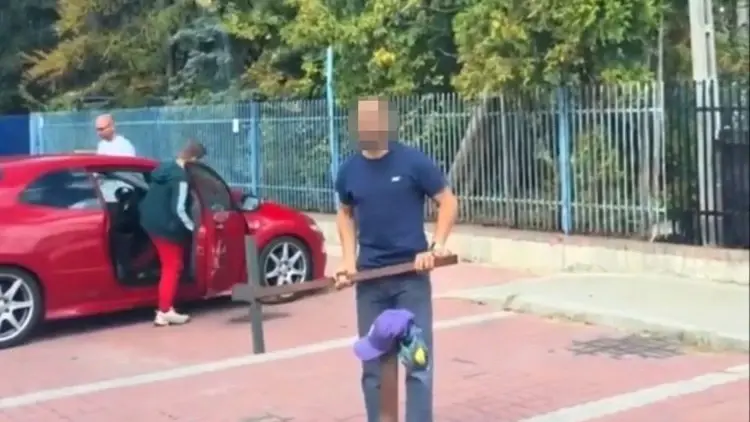 agresor z metalowym słupem atakuje
