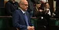 Maciej Berek w Sejmie, w tle dziennikarze
