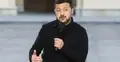 Wołodymyr Zełenski siedzi na krześle na placu i przemawia do mikrofonu