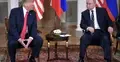 Politycy siedzą obok siebie, w tle flaga USA i Rosji
