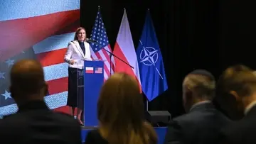 Magdalena Sobkowiak-Czarnecka przemawia na tle flag Polski, NATO i USA